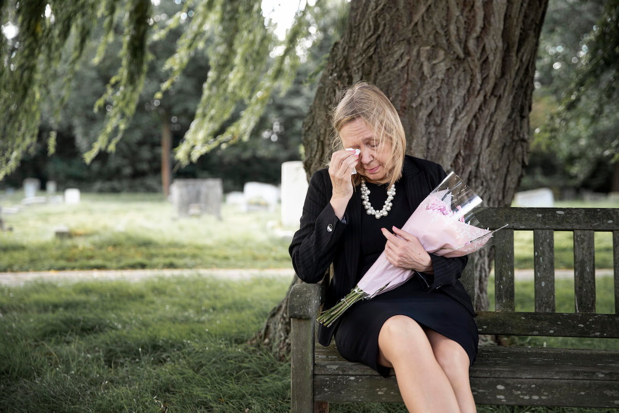 Viúva chorando em cemitério