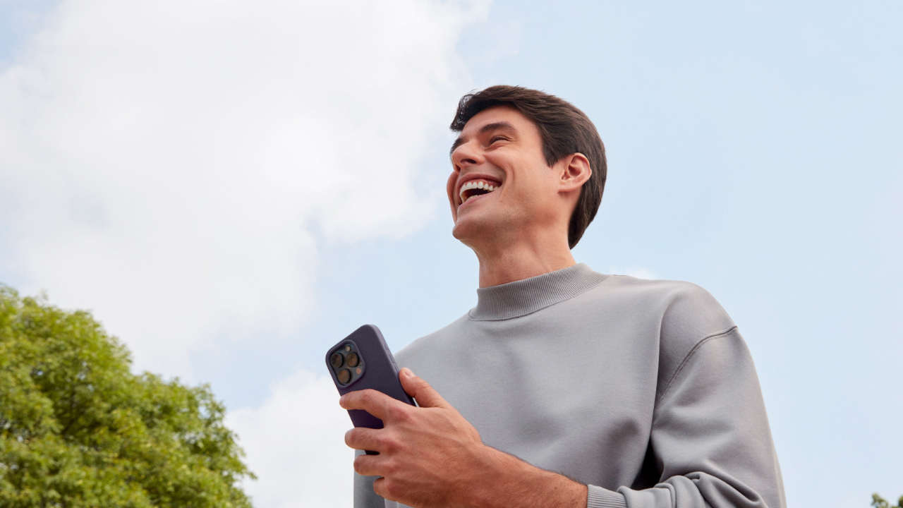 Jovem com celular na mão acessando a conta para menores de 18 do Nubank