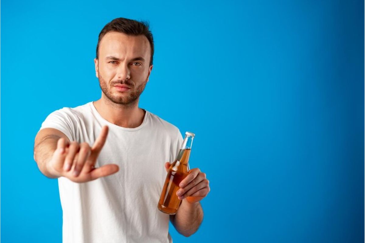 Um homem faz "não" com uma mão e segura uma garrafa com refrigerante na outra após ver as notícias do Imposto do Pecado