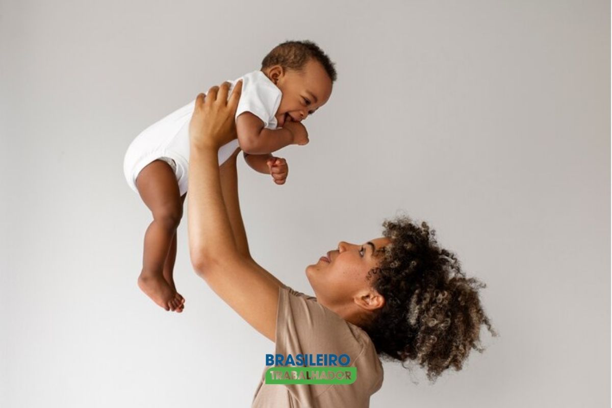 Uma mãe segurando seu filho no alto após ver o Programa Mamãe Cheguei garante kit enxoval gratuito