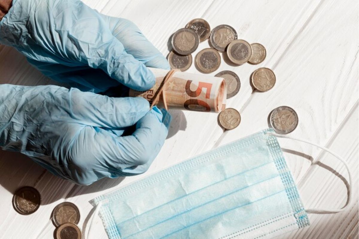 Uma pessoa com um dinheiro na mão com luvas de borrachas após ver os Melhores empréstimos para quem recebe auxílio doença do INSS