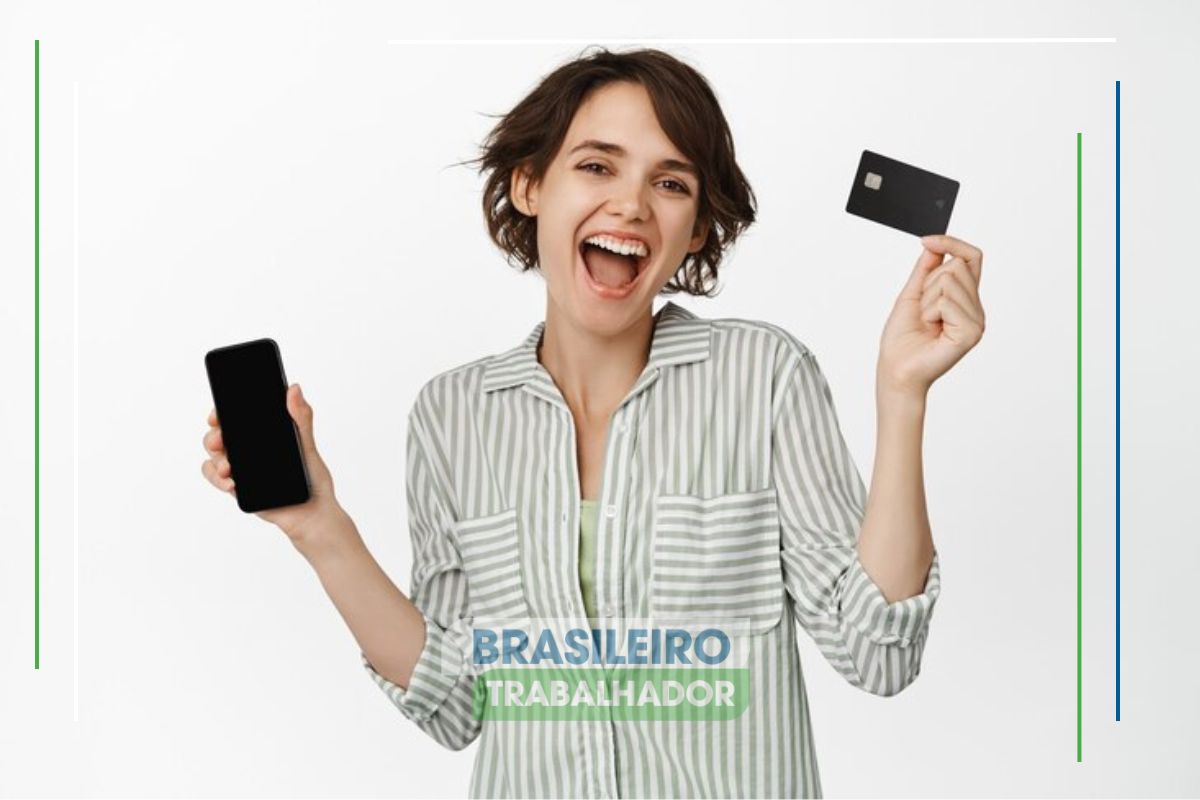 Uma mulher animada segura seu cartão de crédito em uma mão e o celular em outra após ver o Novo perdão de dívidas da Serasa