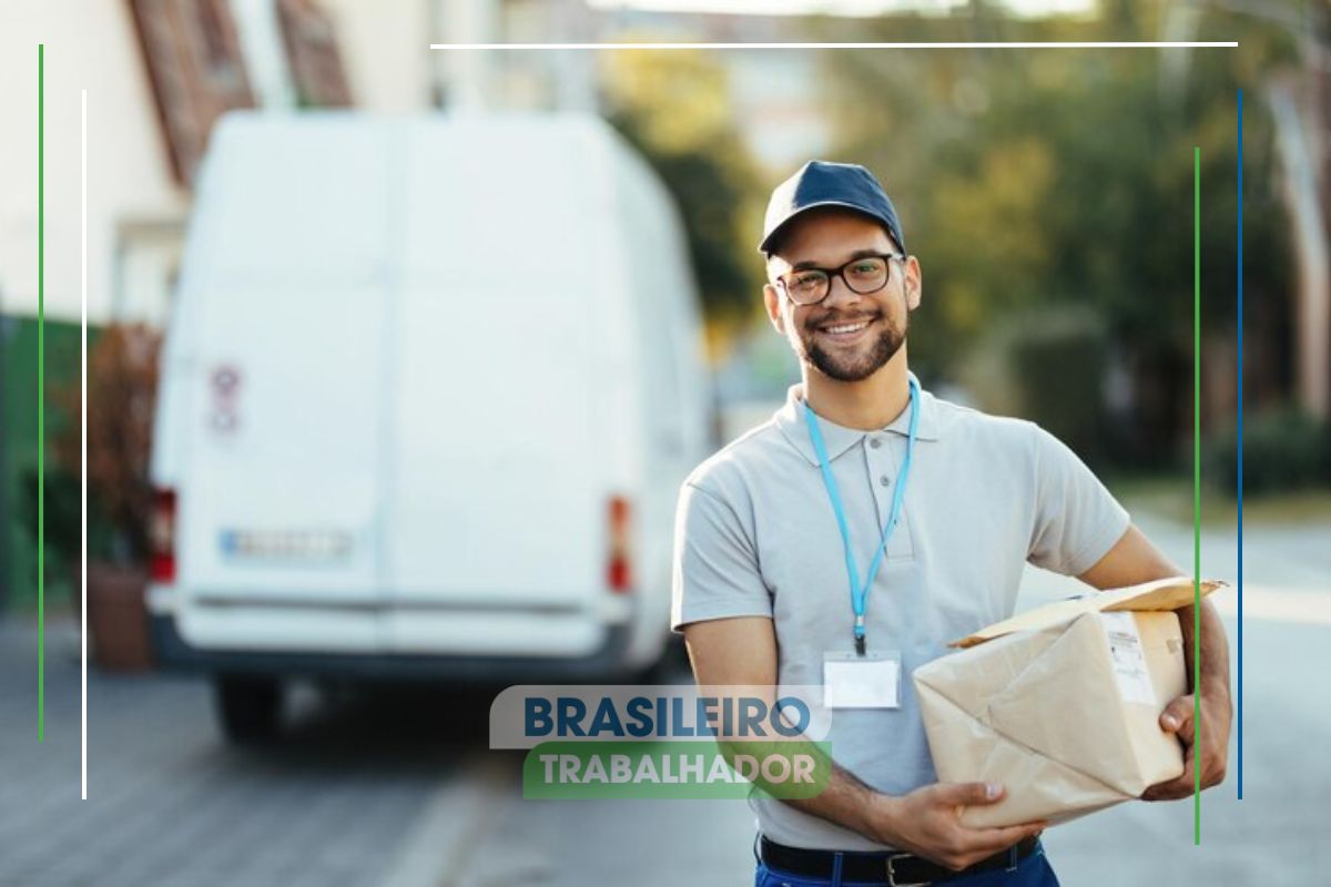 Um entregador com um pacote na mão sorrindo após ver o comunicado Uber