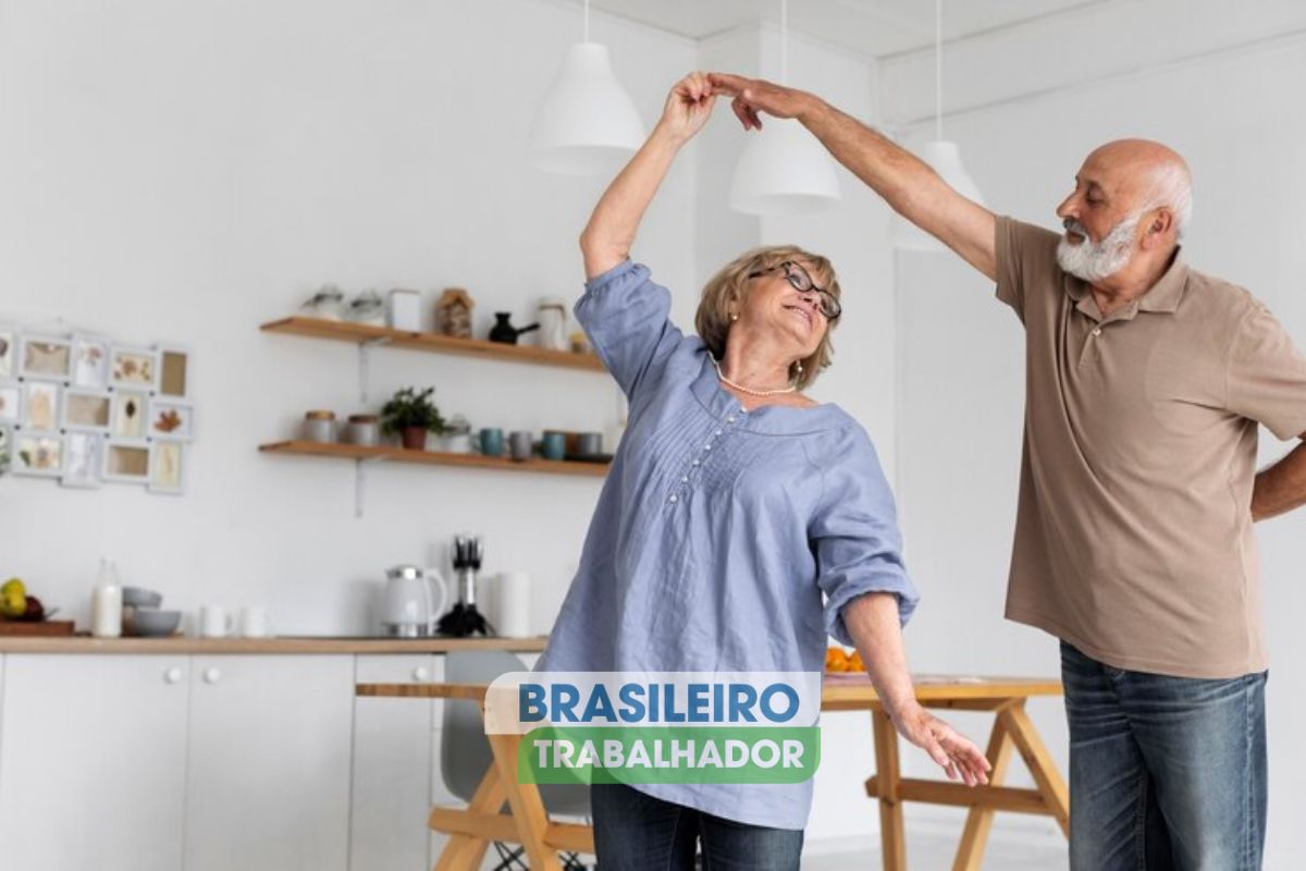 Um casal feliz dançando na sala após ver o novo benefício para idosos