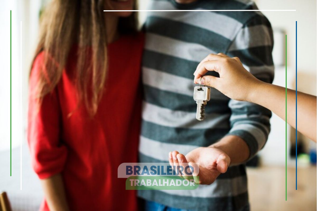 Um casal recebendo a chave da casa após saber que o Programa do Governo Oferece R$ 40.000,00 