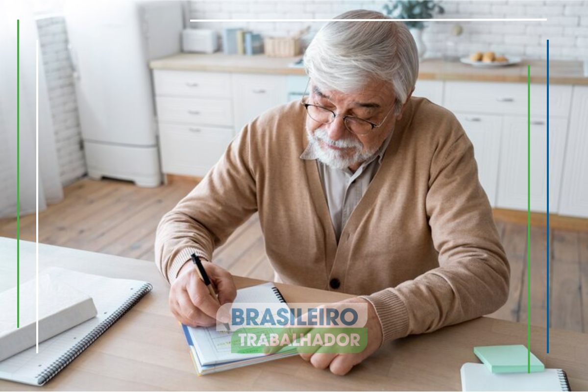 Um senhor sentado na mesa faz anotações no caderno para ver se é possível adotar a aposentadoria aos 50 anos