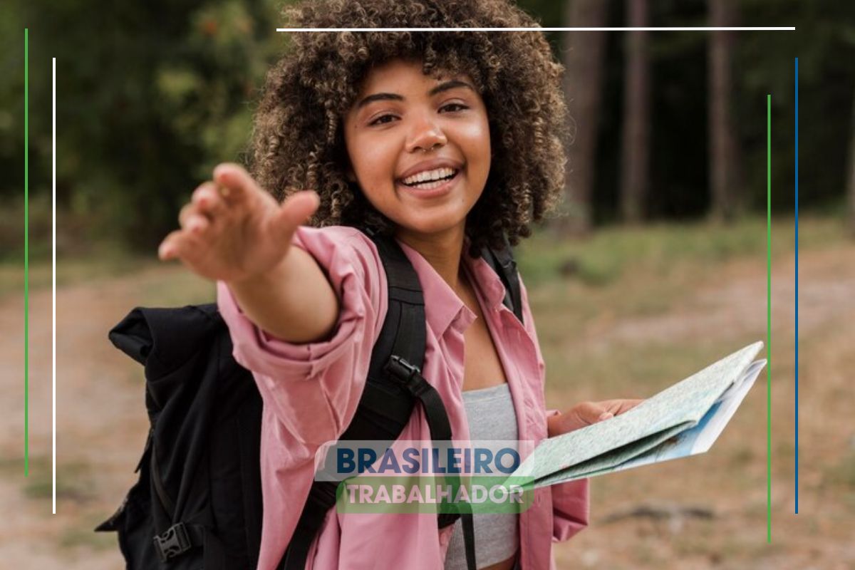 Uma aluina contente anda no bosque e sorri ao ver que Estudantes têm acesso a benefício até dezembro