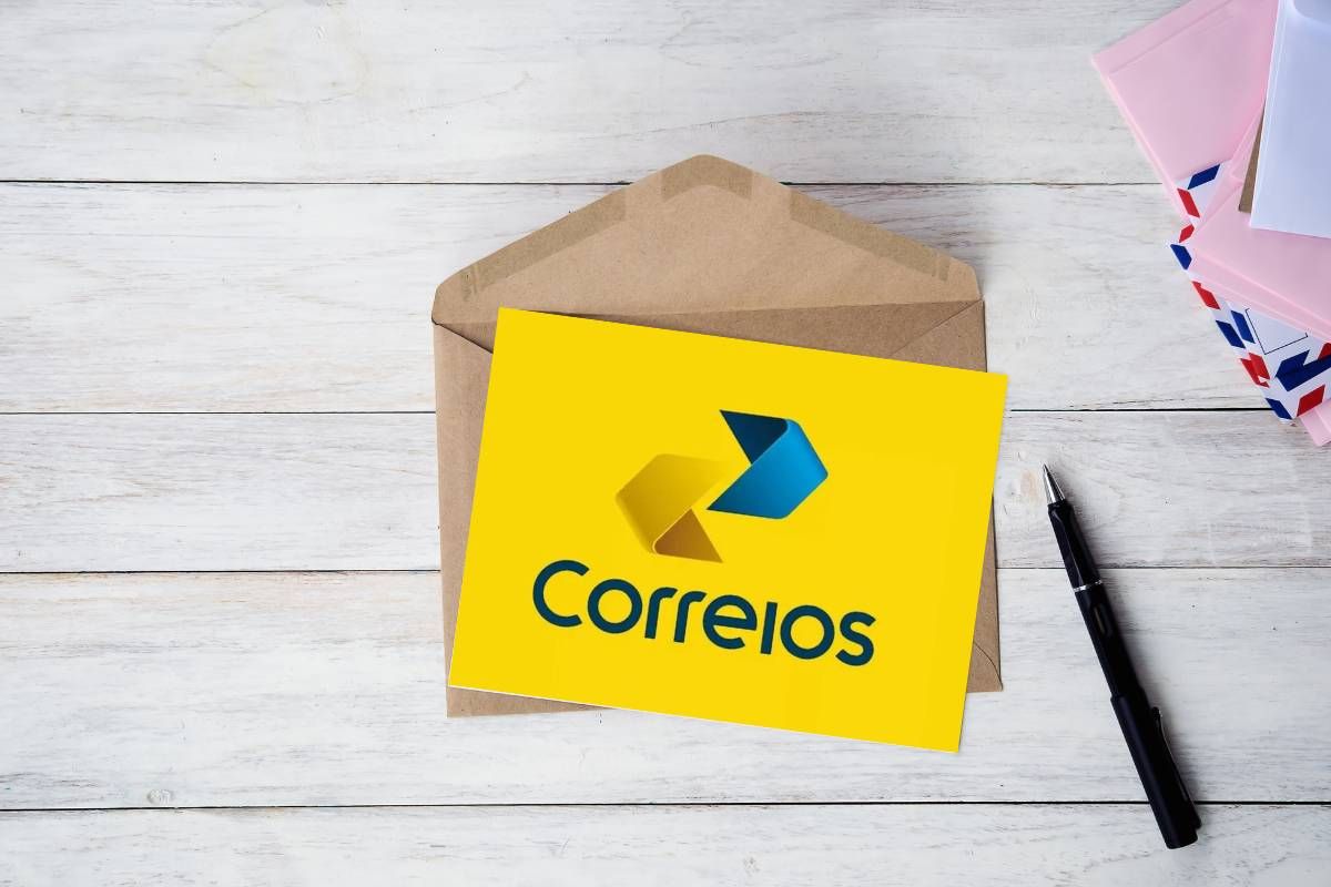 Um pacote dos Correios na mesa, abaixo há um envelope com informações sobre a isenção da taxa no concurso dos Correios