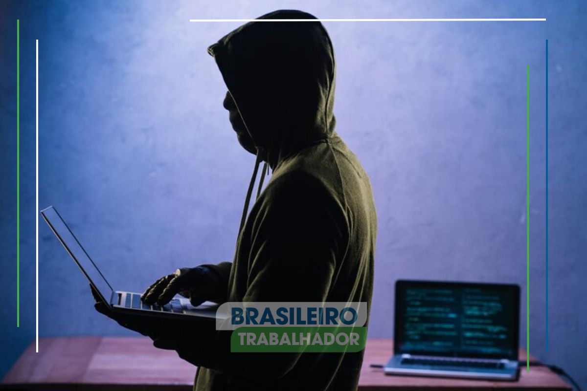 Um hacker segurando um notebook após ver quais sites são os mais perigosos para seus dados pessoais