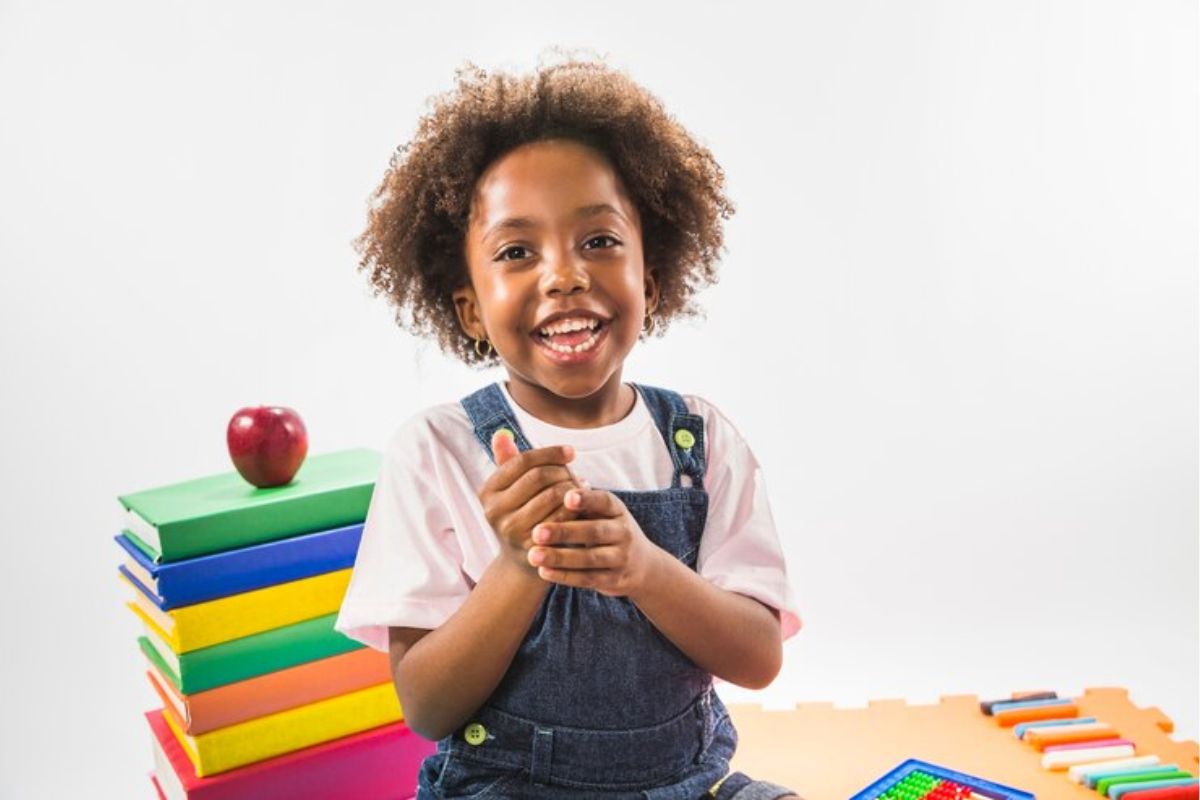 Uma criança animada na escola após ver Quantas faltas escolares o Bolsa Família permite