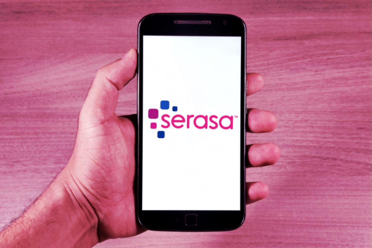 Uma pessoa abrindo o aplicativo em seu celular para conferir o Serasa Score