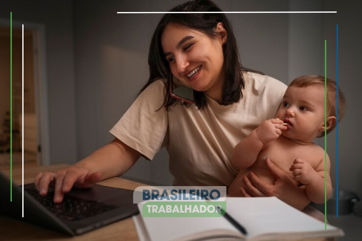 Uma mãe com seu bebê no colo pesquisando no computador MEI: Saiba como receber o auxílio de R$ 1.412