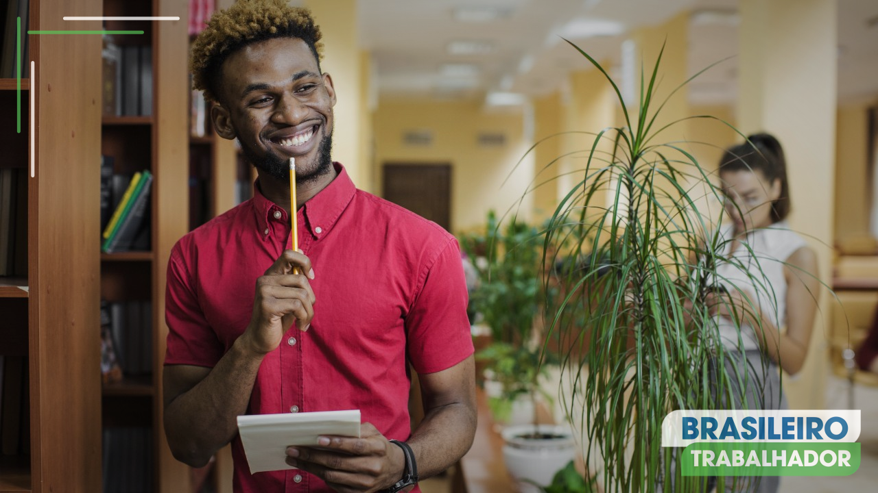 Homem alegre com bloco de notas em trabalho