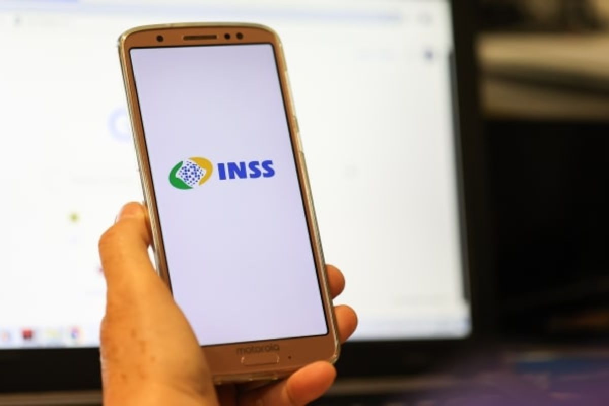 Uma pessoa abre o app em seu celular para conferir o INSS bloqueado para empréstimo