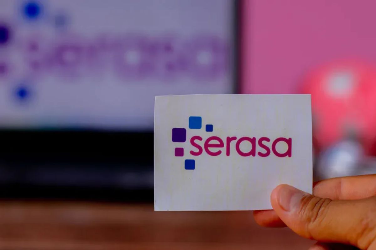 Uma mulher com o cartão da Serasa na mão após ver que a Serasa lança BENEFÍCIO INÉDITO