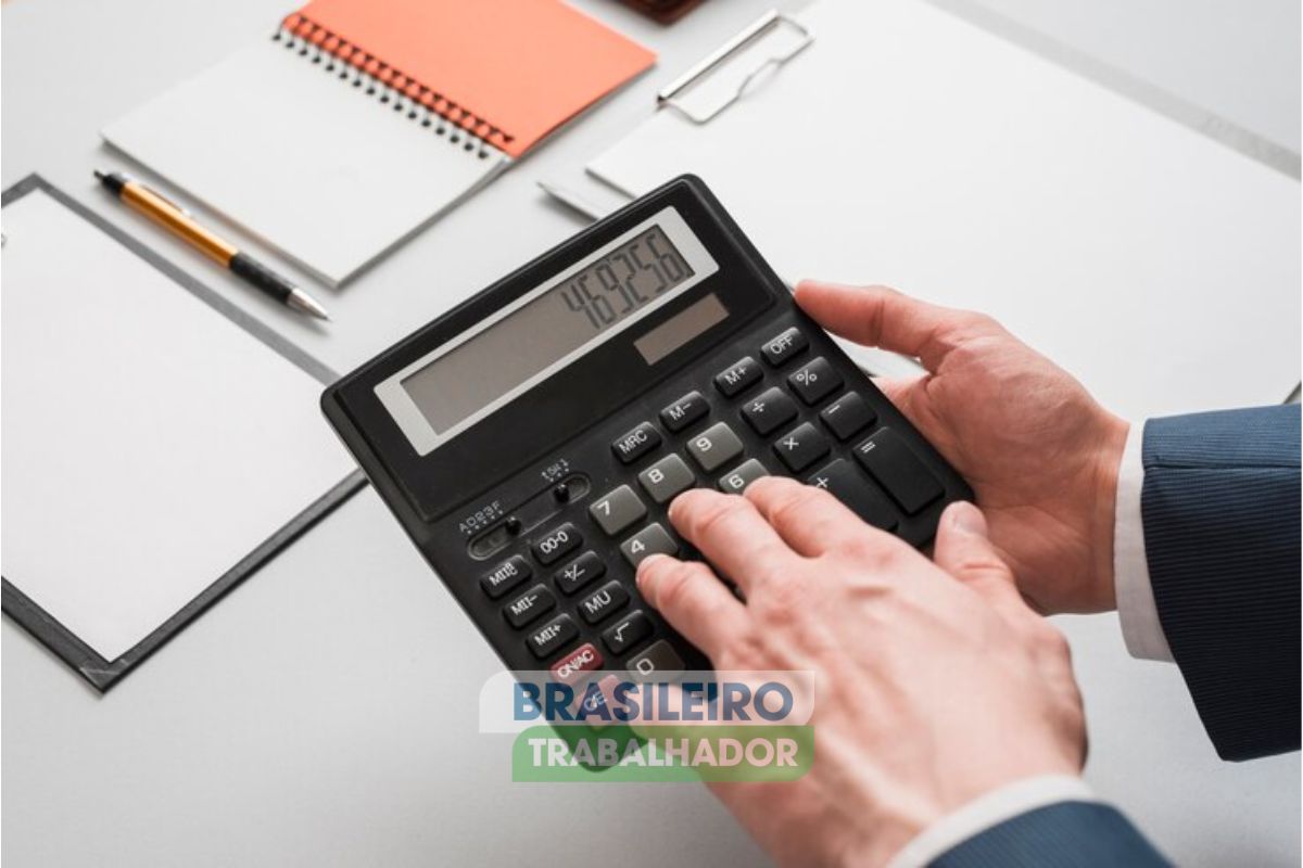 Um rapaz usando uma calculadora com o simulador do INSS para saber quando vai se aposentar