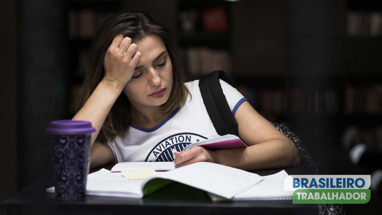 Menina sentada na mesa com leitura de cadernos