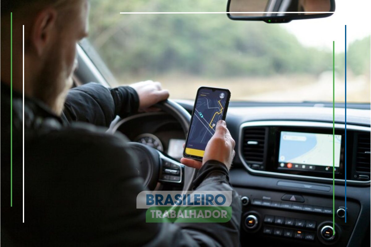 Um motorista em frente ao volante mexendo em seu aplicativo de GPS após ver que Motoristas Uber fazem R$ 6.500