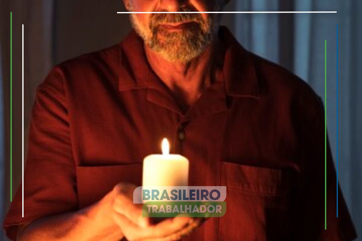 Um senhor segurando uma vela no escuro depois que um Blackout deixa 120 mil residências no escuro