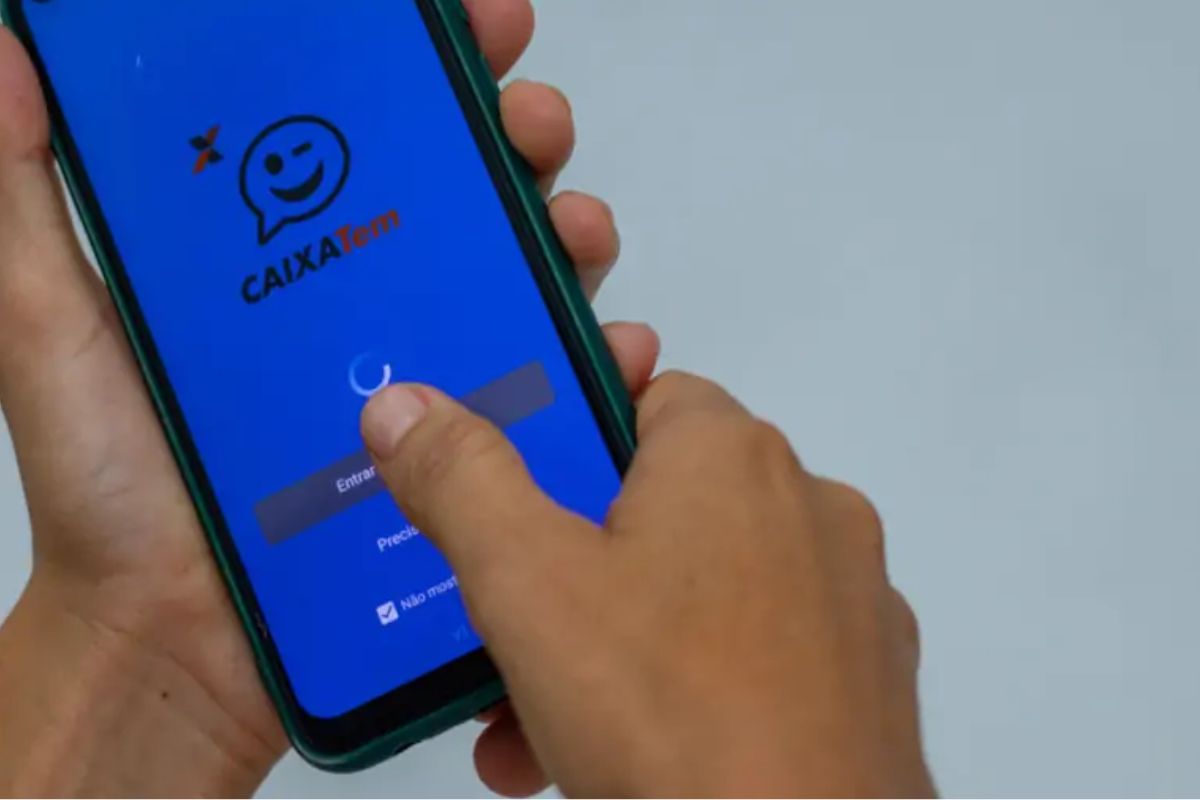 Uma pessoa segura o smartphone enquanto o aplicativo carrega em sua mão já que a Caixa Econômica enfrenta instabilidade no app