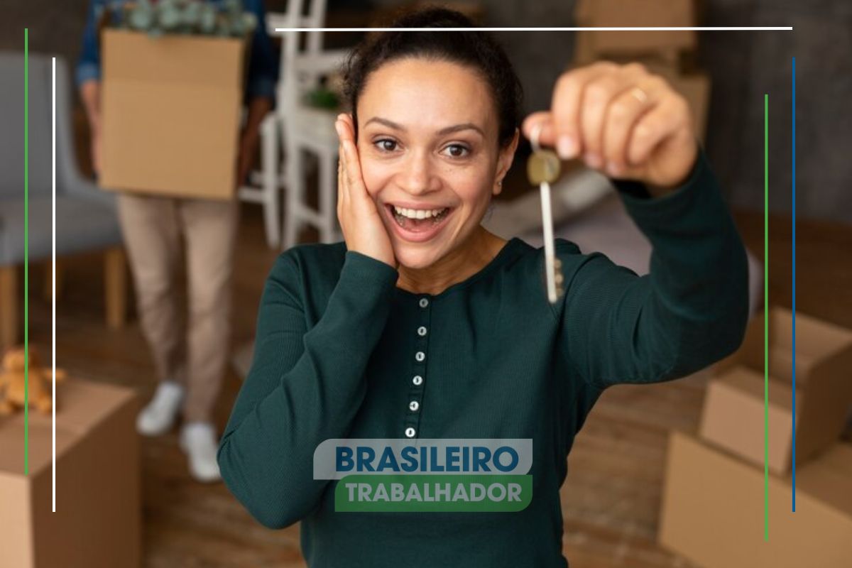 Uma mulher impressionada segura a chave de sua casa. Ela está na sala e vê sua casa própria mais perto do que nunca