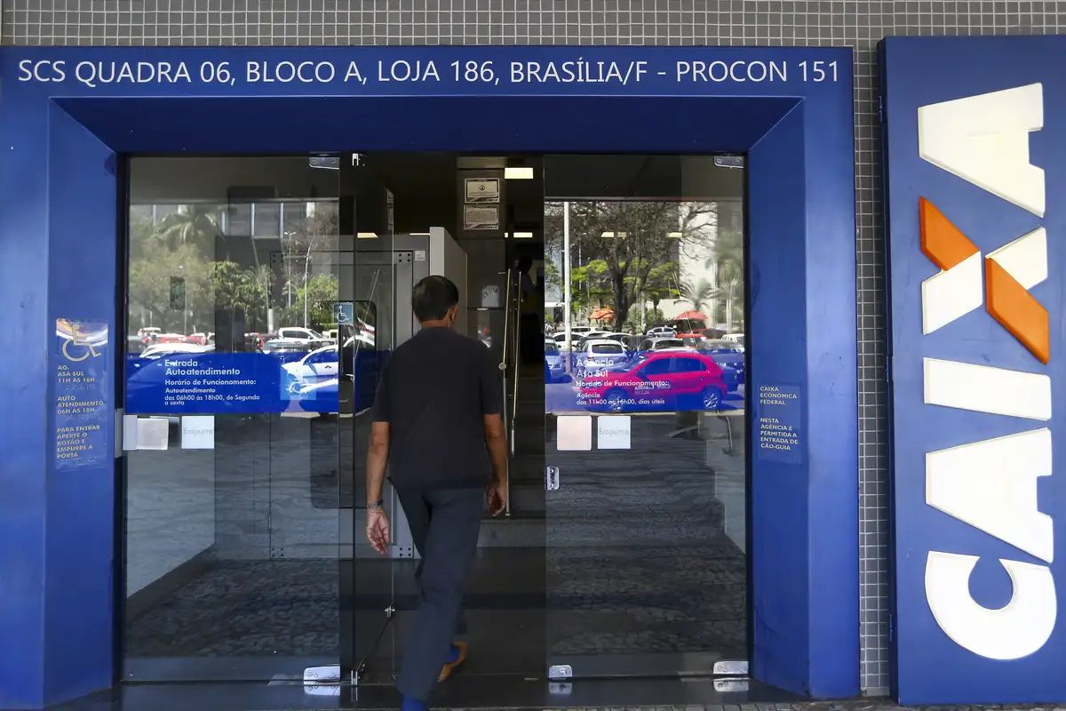 Um homem entrando na agência após ver que Clientes da CAIXA devem se atentar a NOVAS REGRAS