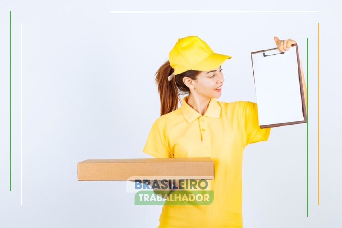 Uma agente de uniforme amarelo segura uma caixa de papelão e prancheta após ver que os Correios fecham novo acordo coletivo