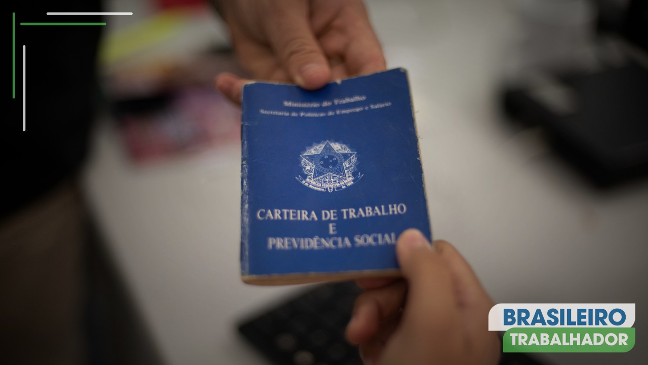 Duas pessoas segurando uma Carteira de Trabalho