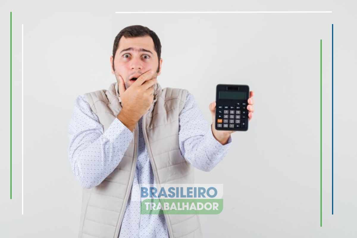 Um homem assustado com a COBRANÇA EXTRA NA CONTA DE LUZ segura uma calculadora