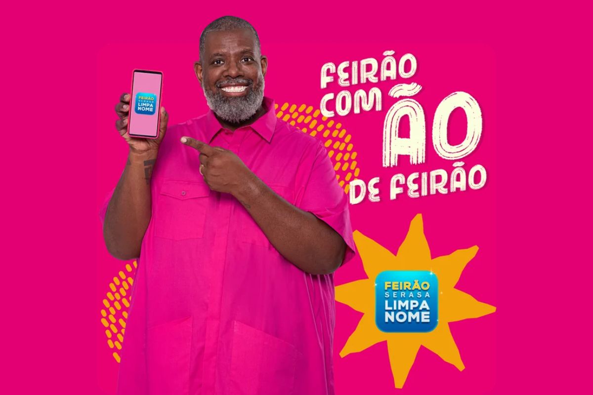 Péricles segurando um celular fazendo um anúncio de que Endividados recebem aviso da Serasa