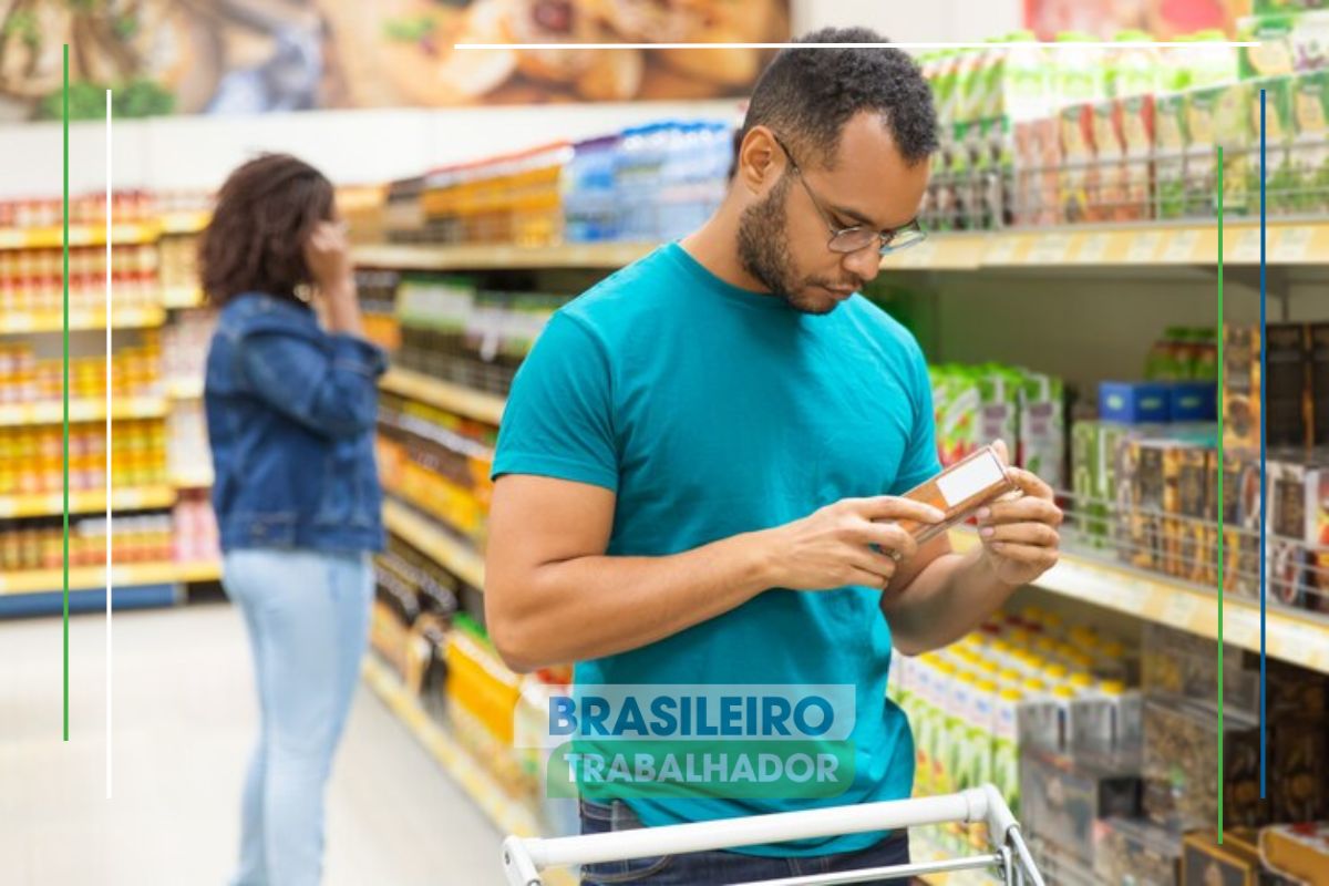 Um rapaz no mercado olhando o preço de um produto que teve aumento na Cesta básica em Campinas