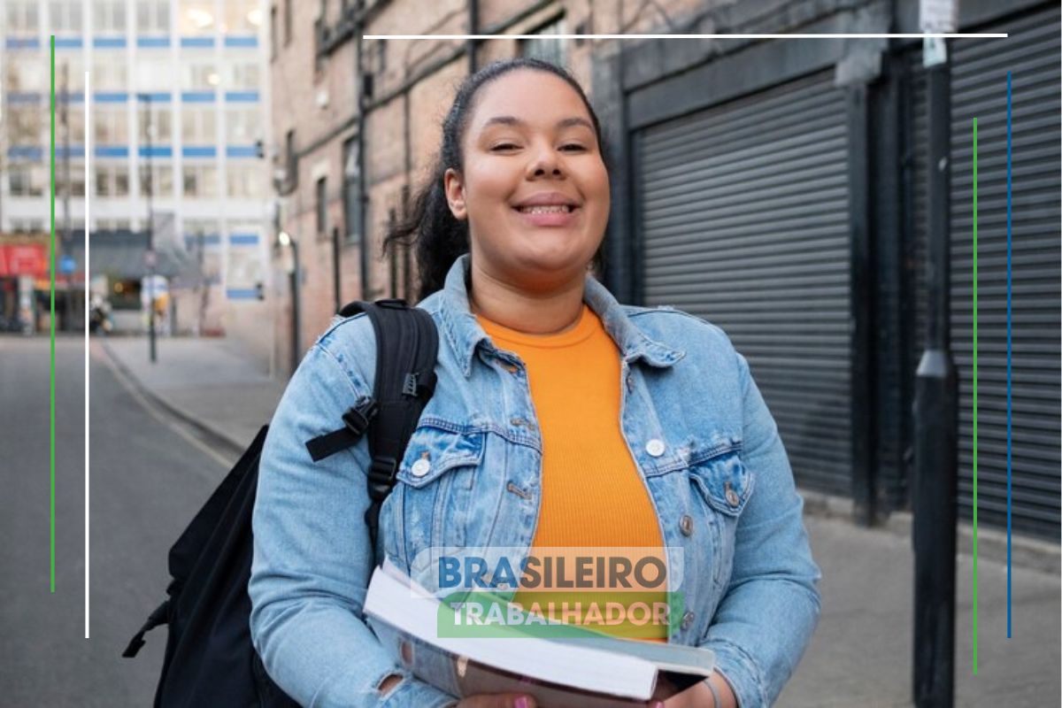 Uma estudante sorri na rua após ver Como garantir sua vaga no Sisu, Prouni, Fies e Enem