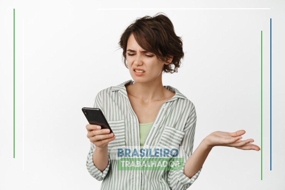 Uma mulher segura o celular na mão confusa com o Erro 0555 no CAIXA TEM