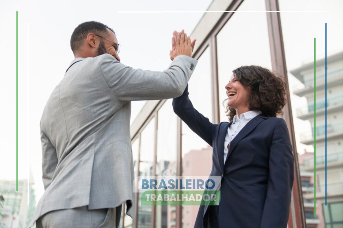 Um casal de sócios tocando as mãos na rua, eles estão felizes depois de descobrirem que o Programa Acredita oferece empréstimos com condições especiais