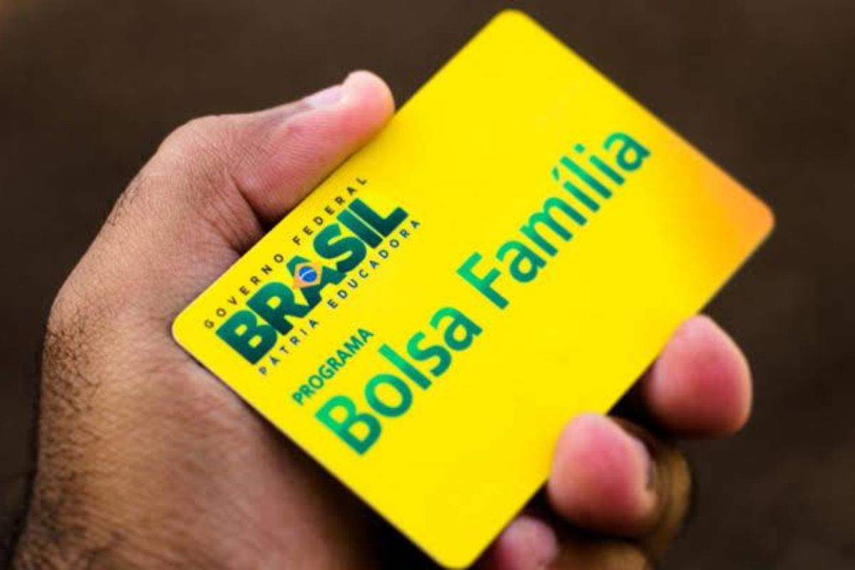 Uma pessoa segurando o cartão do benefício se questionando se o saldo do FGTS interfere no Bolsa Família