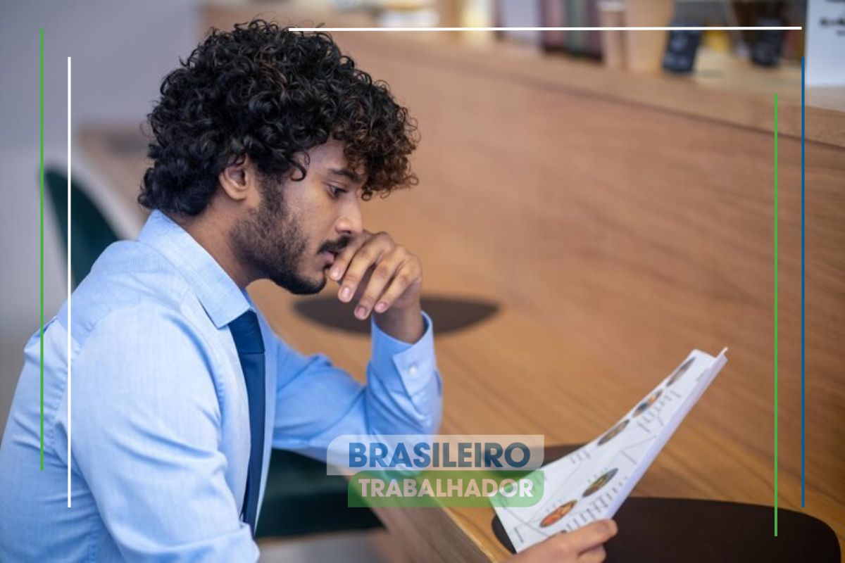 Um empresário em seu escritório olha alguns papéis em sua mão e observa o fim do prazo para MEI e empreendedores