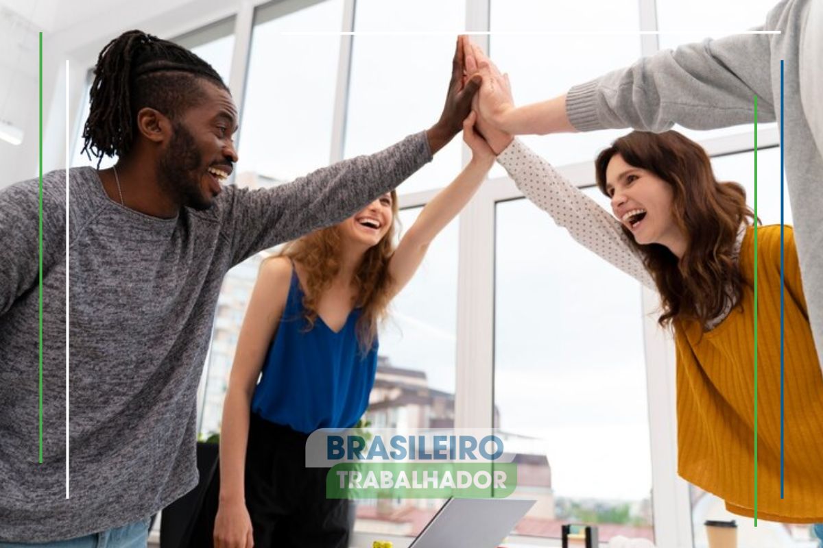 Um grupo de trabalhadores no escritório comemorando a 2ª parcela do 13º