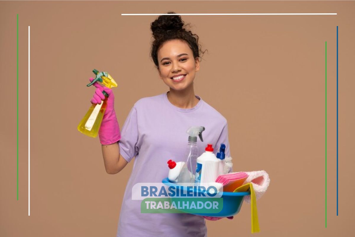 Uma mulher com produtos de limpeza nas mãos sorrindo após ver as leis que o patrão de empregados domésticos deve seguir