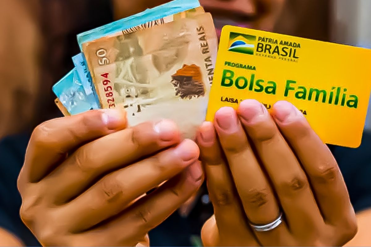 Uma mulher com cartão do benefício e dinheiro do Bolsa Família 2025