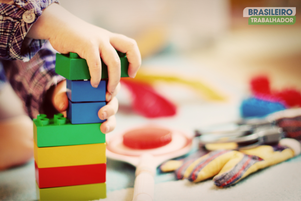 Criança brincando com alguns brinquedos no chão
