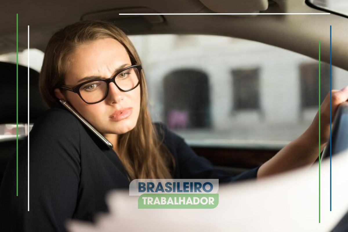 Uma mulher no carro com o documento do IPVA 2025