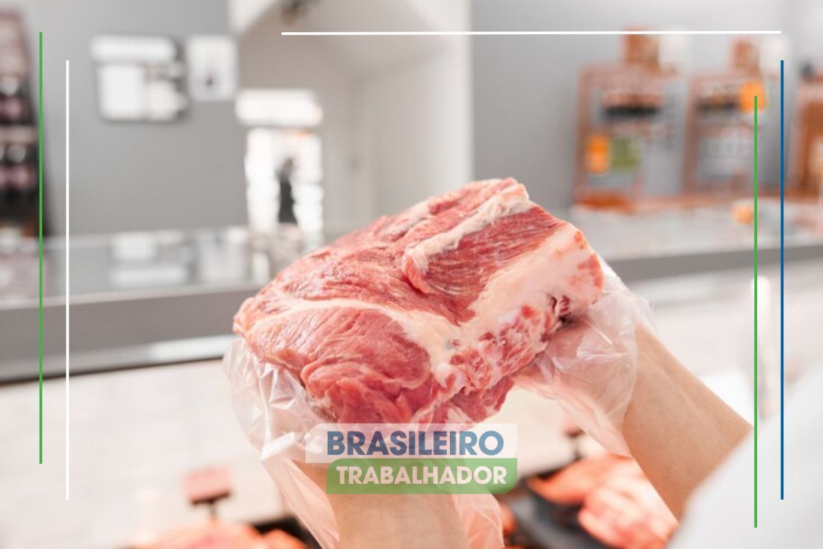 Um açougueiro com uma peça na mão, indicando que o Preço da carne aumenta em 2024