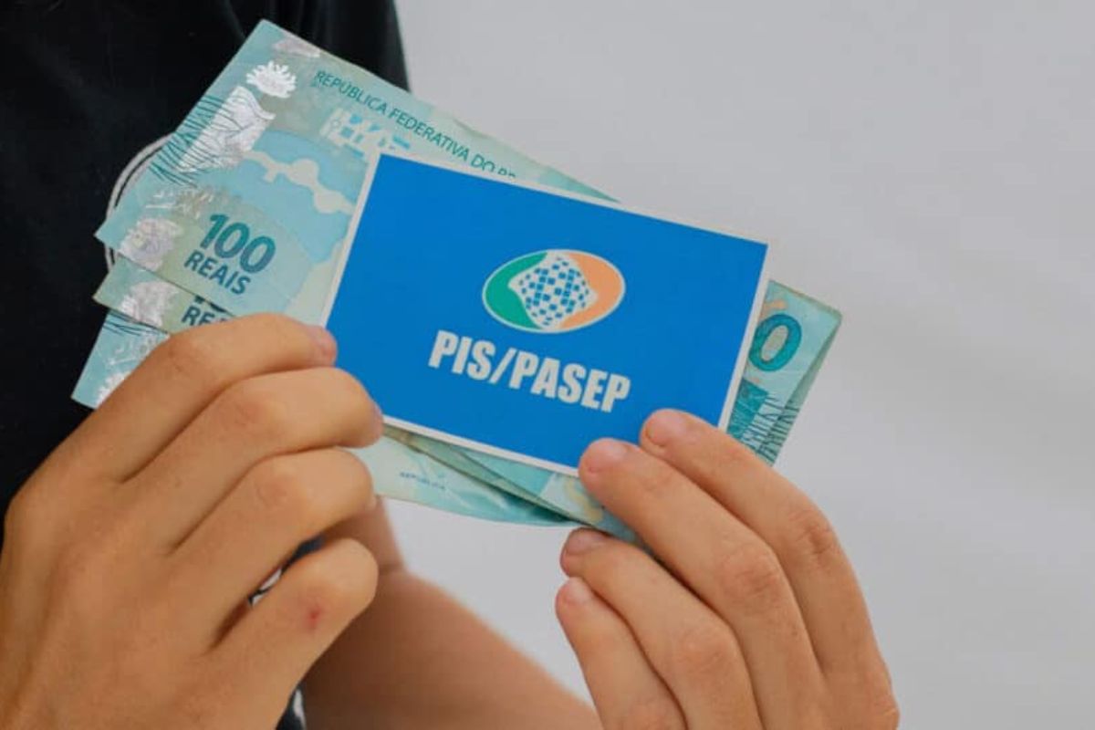 Uma pessoa com o dinheiro na mão após ver o Calendário do PIS/PASEP 2025