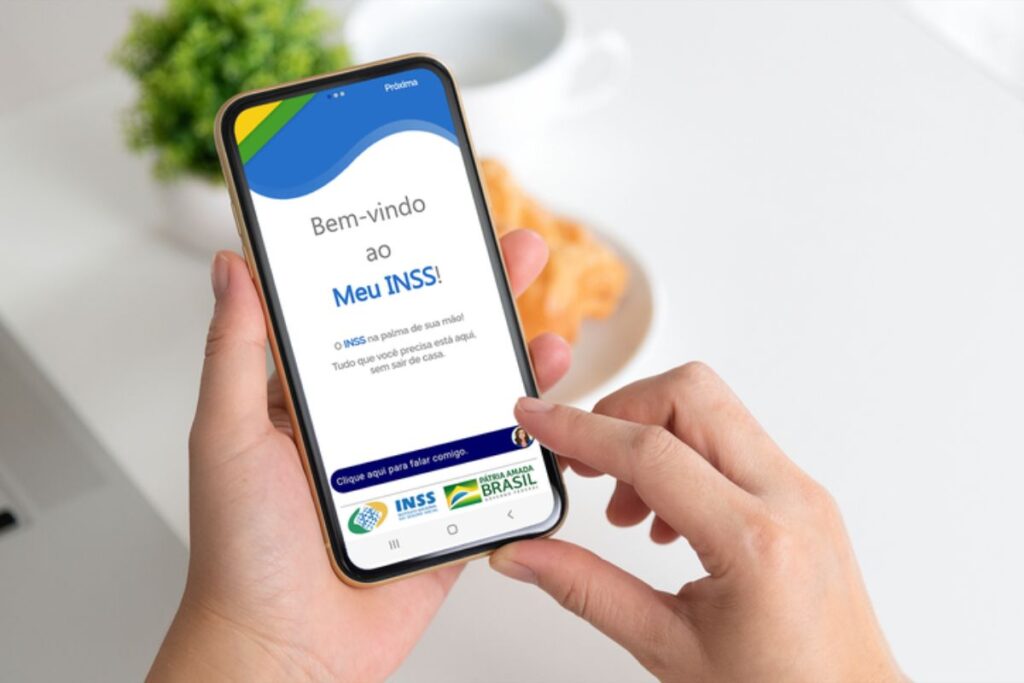 Meu Inss em um celular. App aberto na mão de uma pessoa