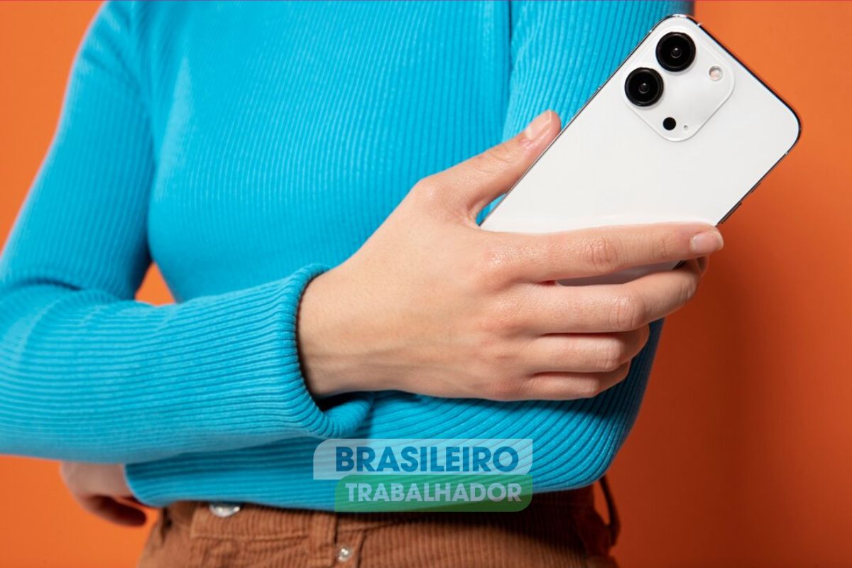 Uma mulher de braços cruzados com um smartphone da Apple