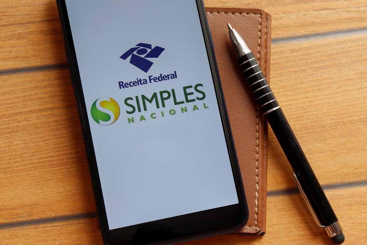 Celular com o Simples Nacional, com uma caneta ao lado